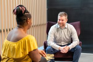 Jeff sitting across from Ann, and listening deeply to what she is sharing with him.